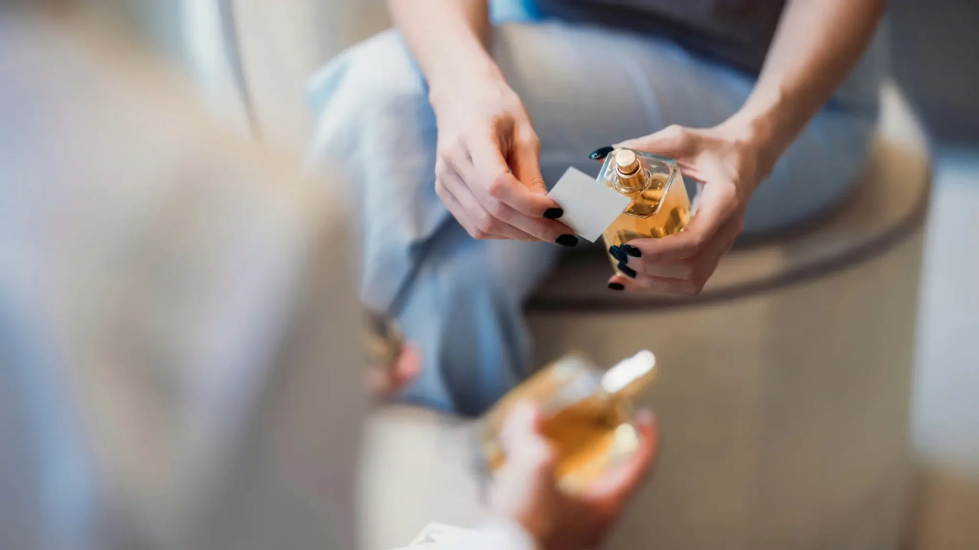 Person holding and examining a small dog figurine indoors.